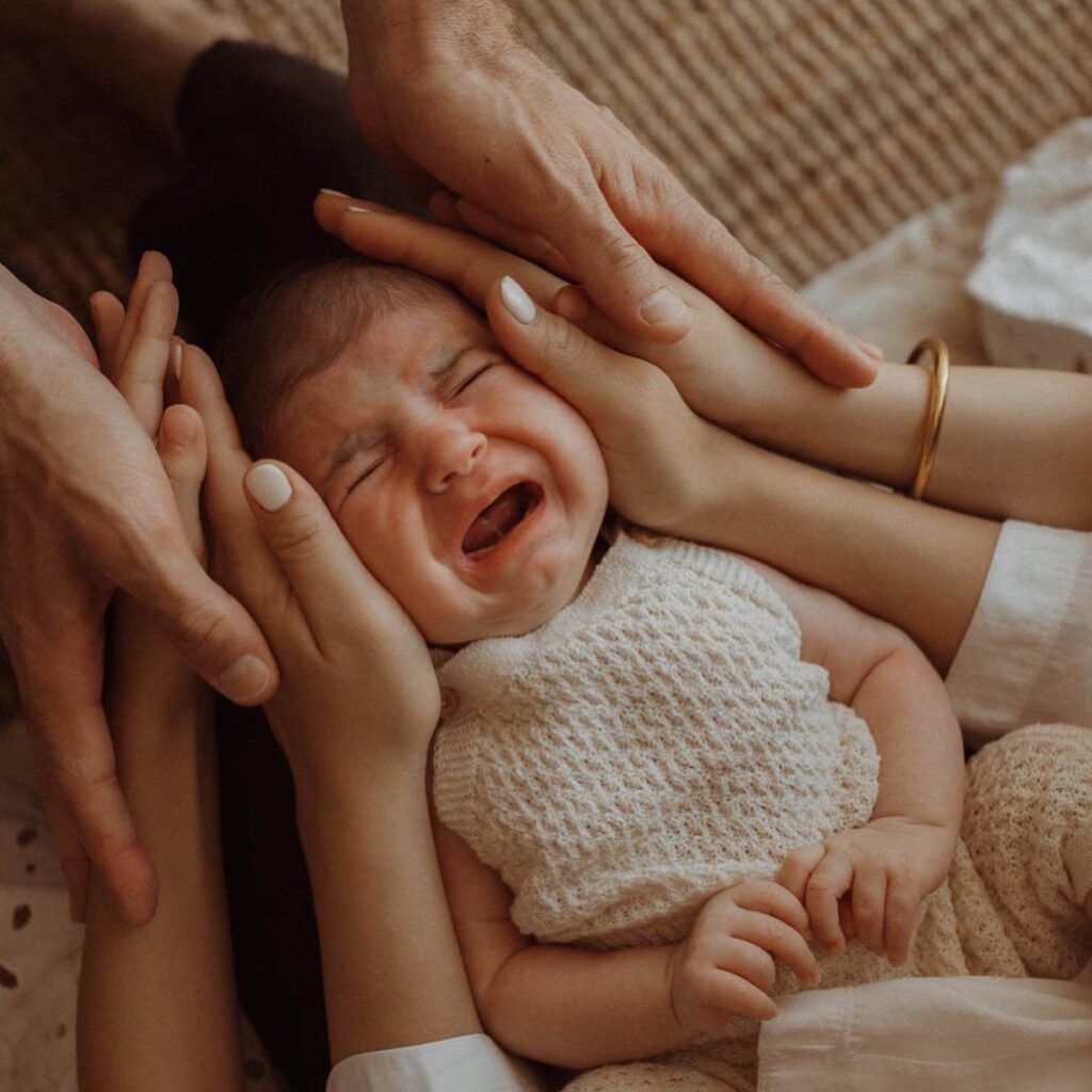 Parents Comforting Crying Baby At Home