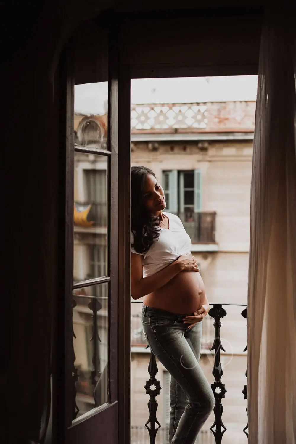 Pregnant woman at home balcony photography.