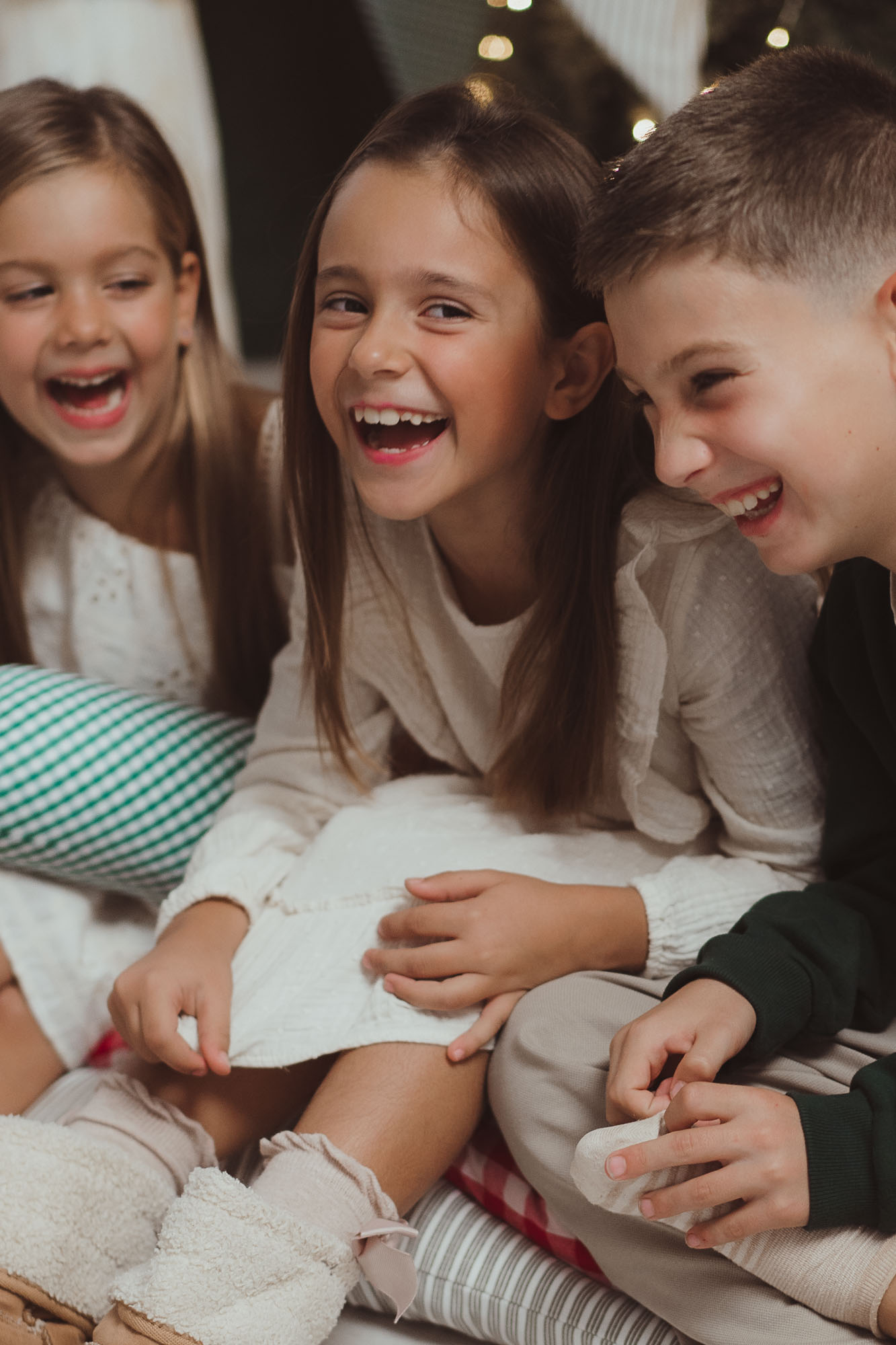 christmas photos at home kids laughing in bed with mug