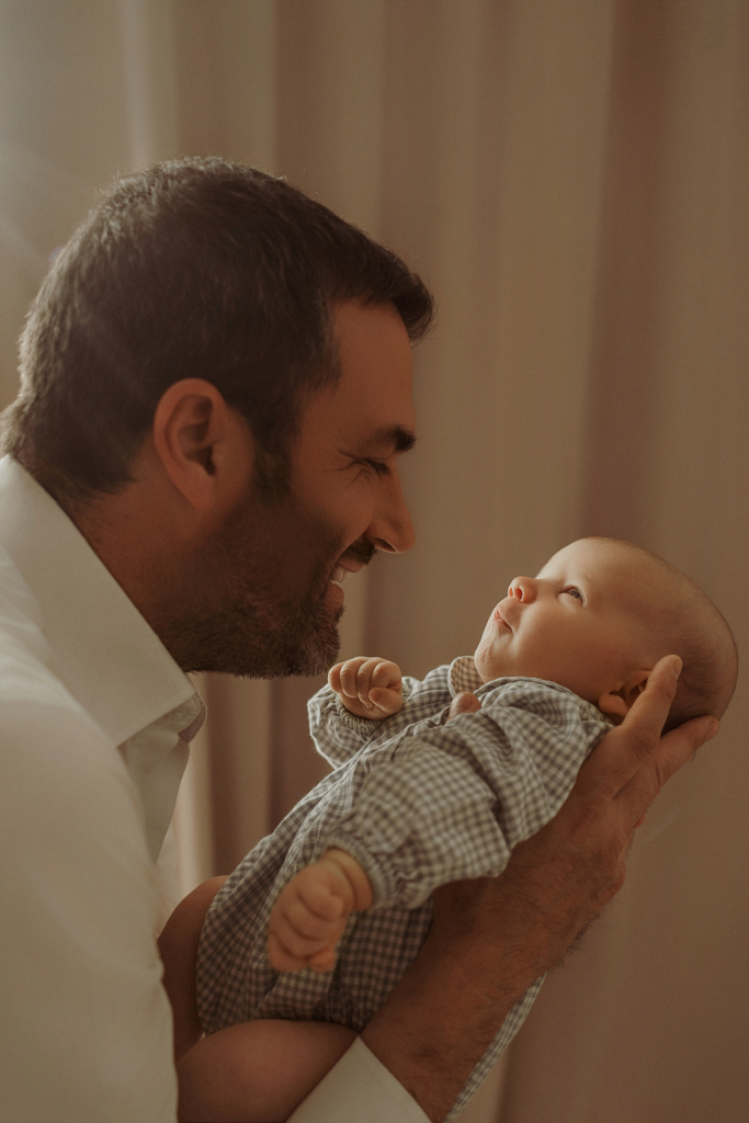 Papá mirando a su recién nacido en una sesión newborn con Tami