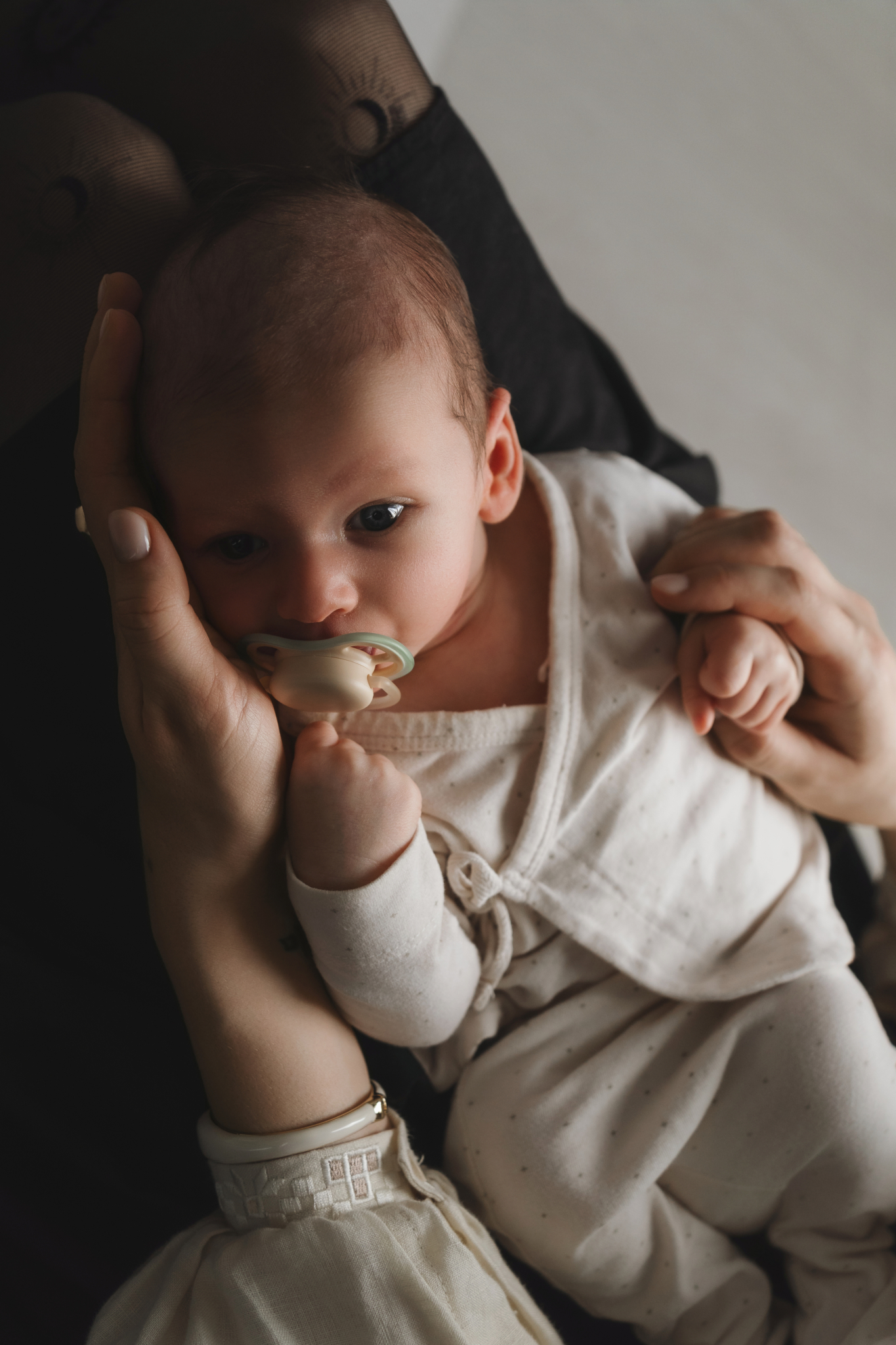 baby pacifier mom hands newborn photos at home