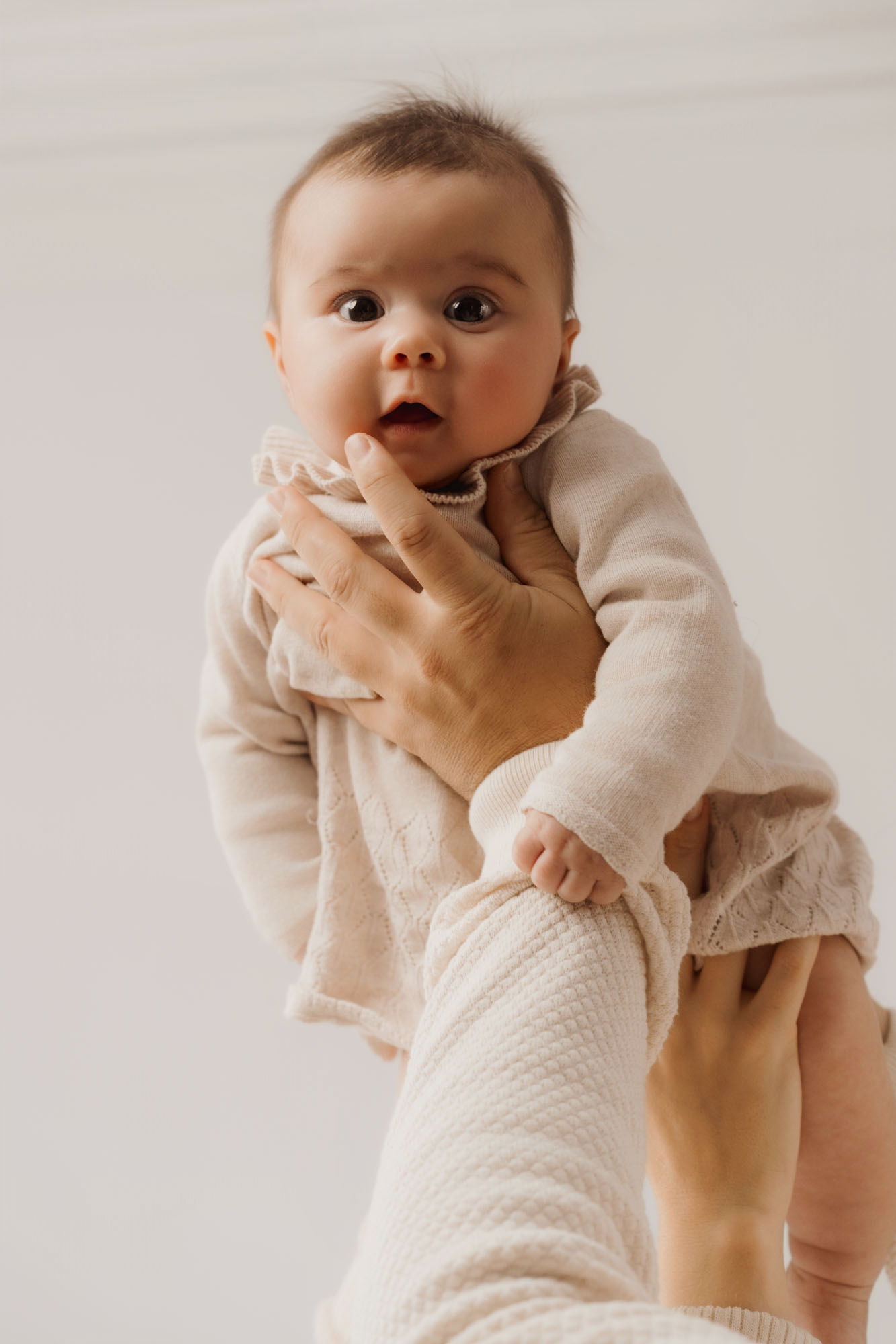 baby gaze dad hands newborn photos at home
