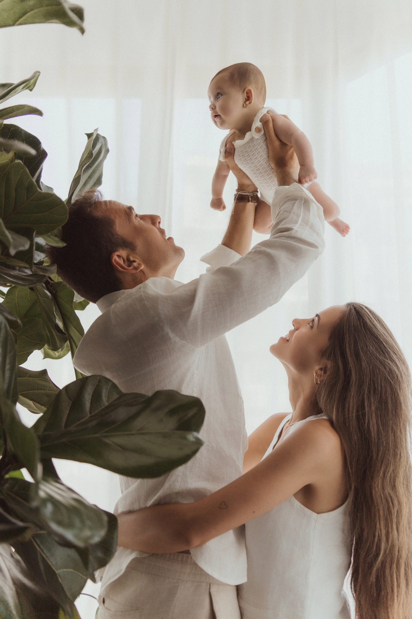 family of three dad lifting baby cheerful original studio family photos