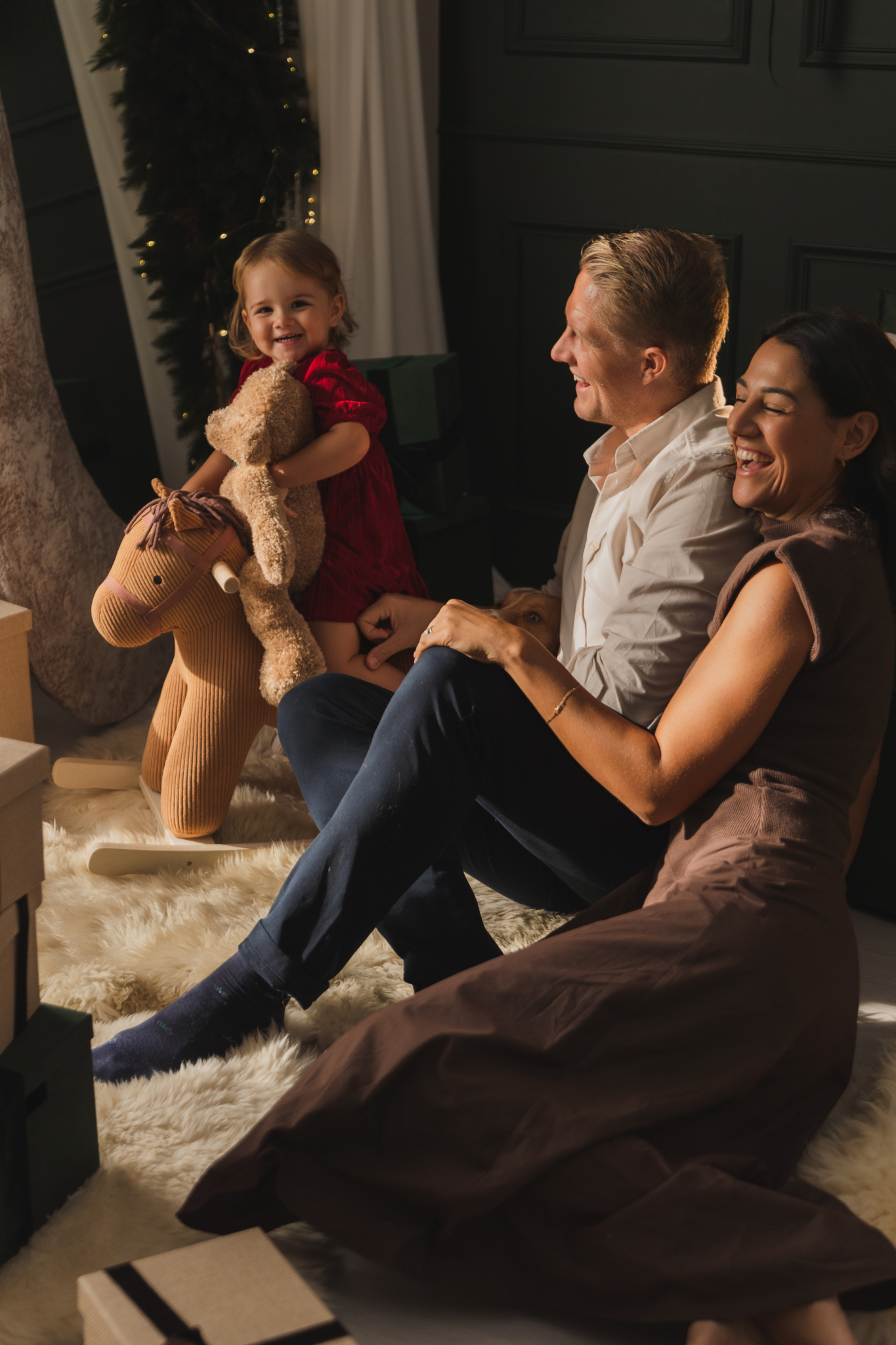 fotos navidenas familiares padres hija riendo peluche caballito