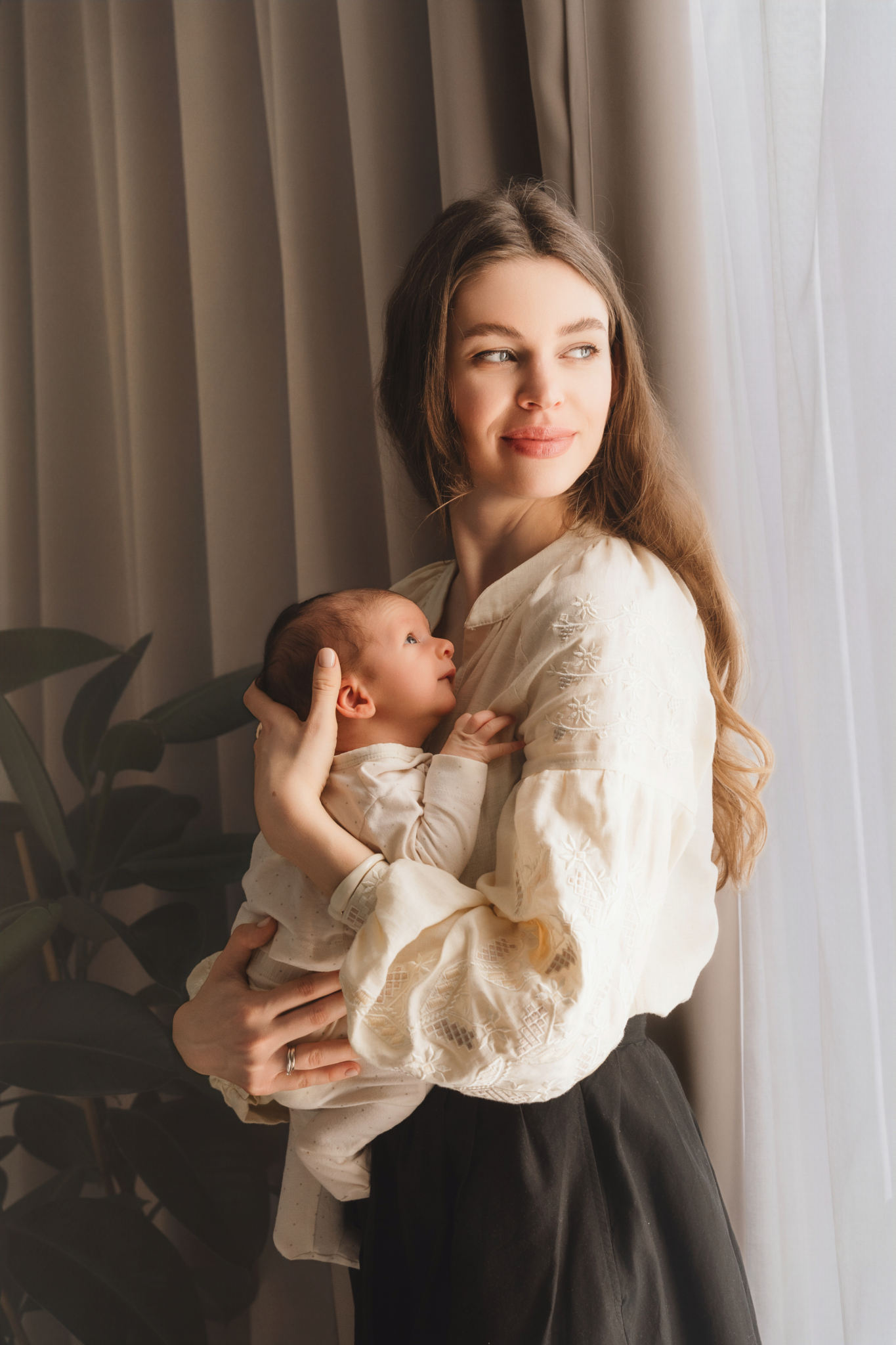 mom arms baby window light newborn photos