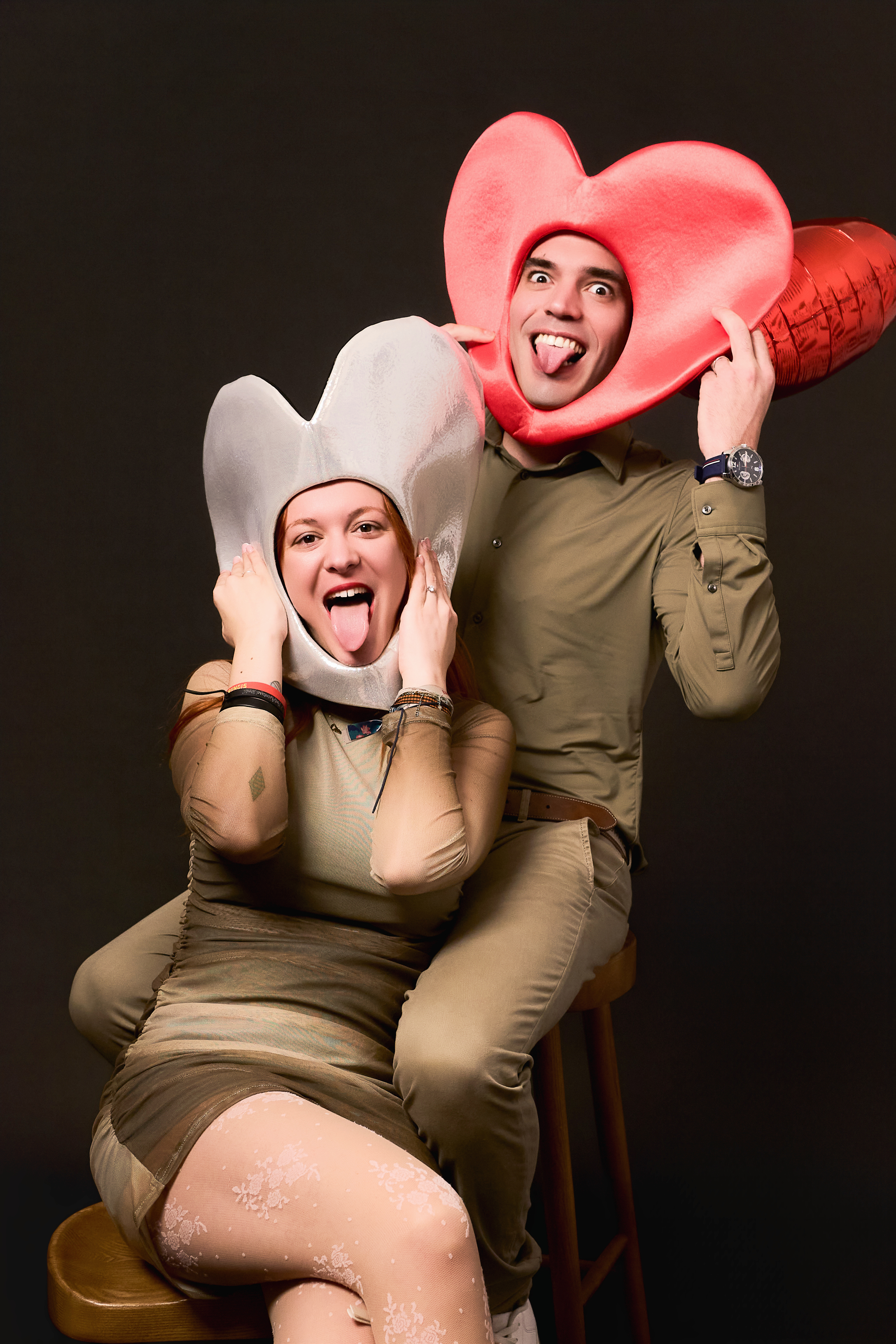 Couple having fun with inflatable hearts in creative studio photoshoot