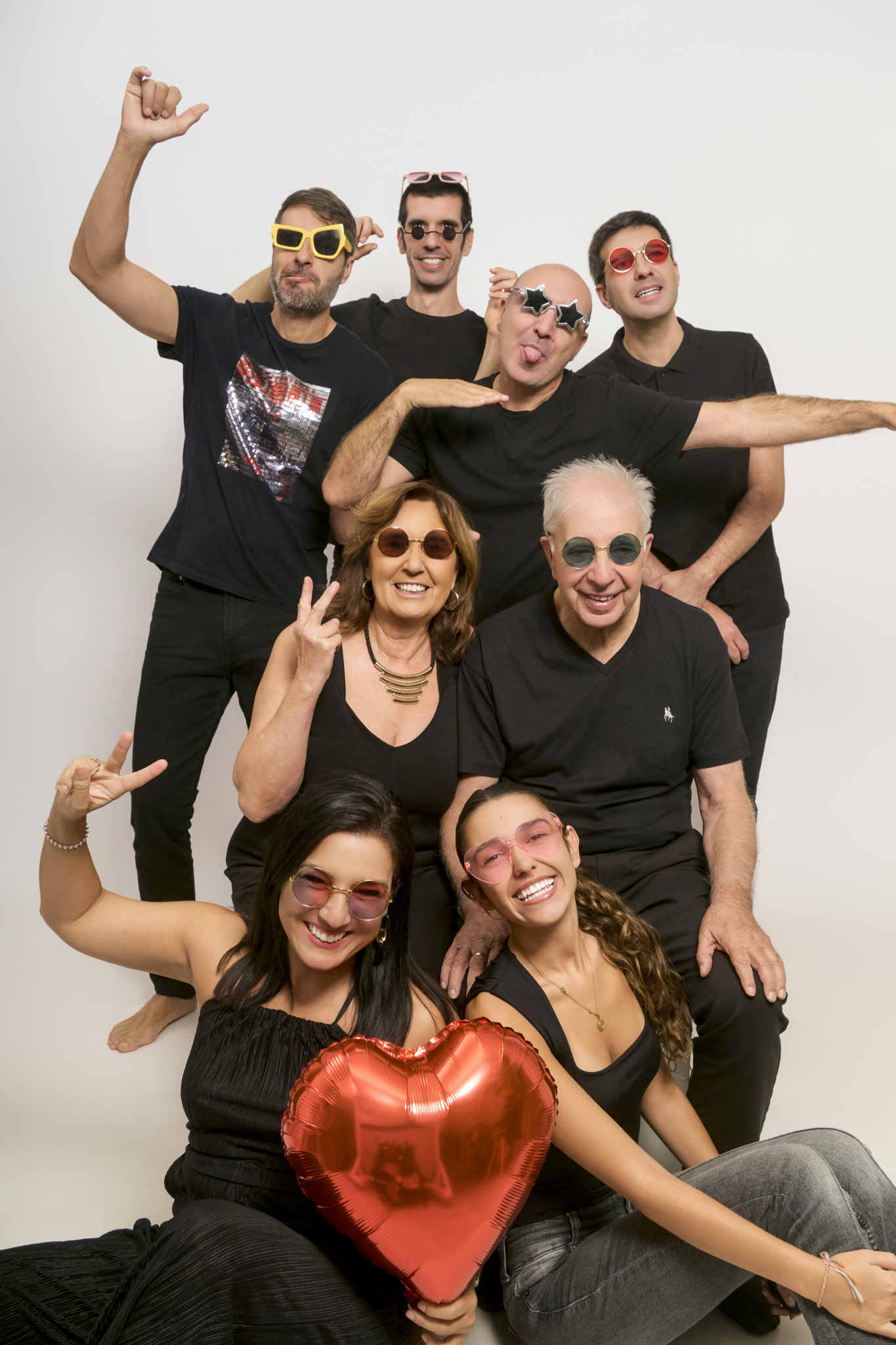 Familia reunida con gafas de sol y globo corazón celebrando bodas de oro en estudio Barcelona