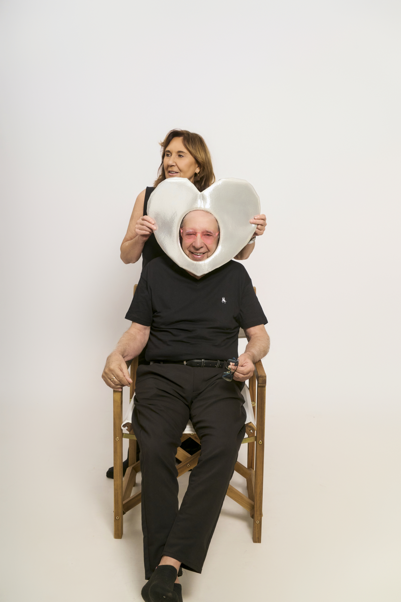 Pareja celebrando bodas de oro retrato divertido con marco corazón en self-photo studio