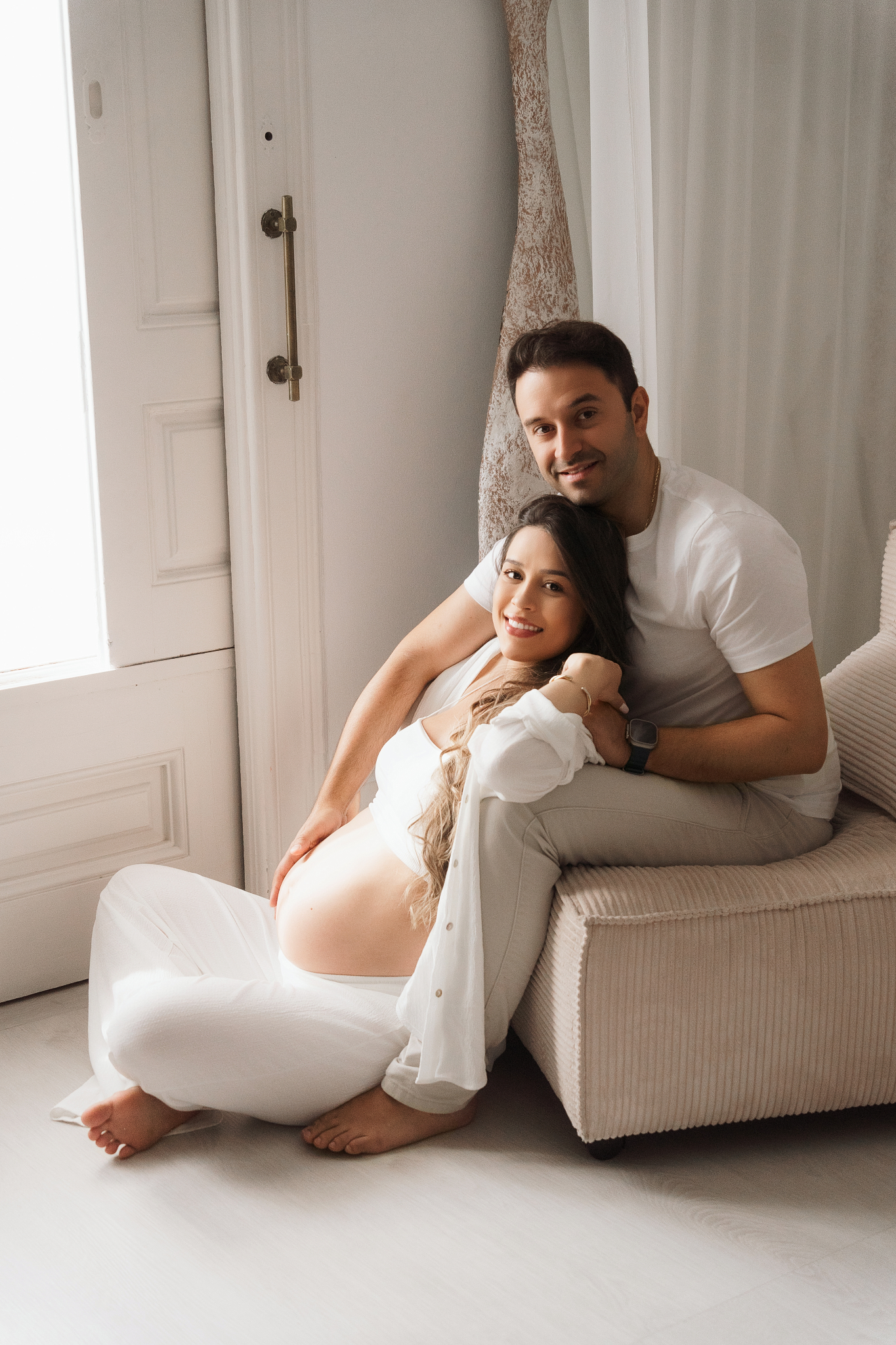 fotos embarazo pareja sonriendo sofa blanco barriga visible