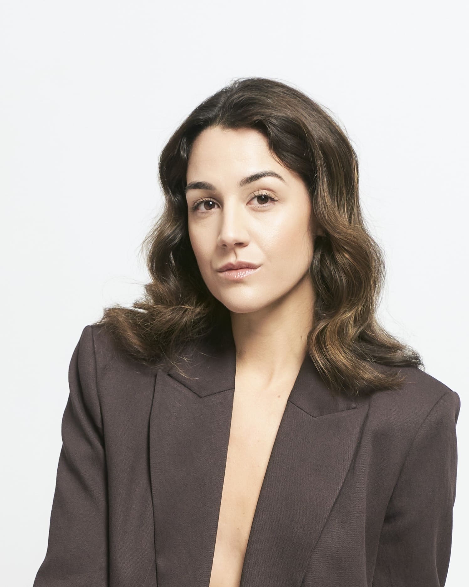 Woman in blazer, professional LinkedIn photo with direct eye contact on white background