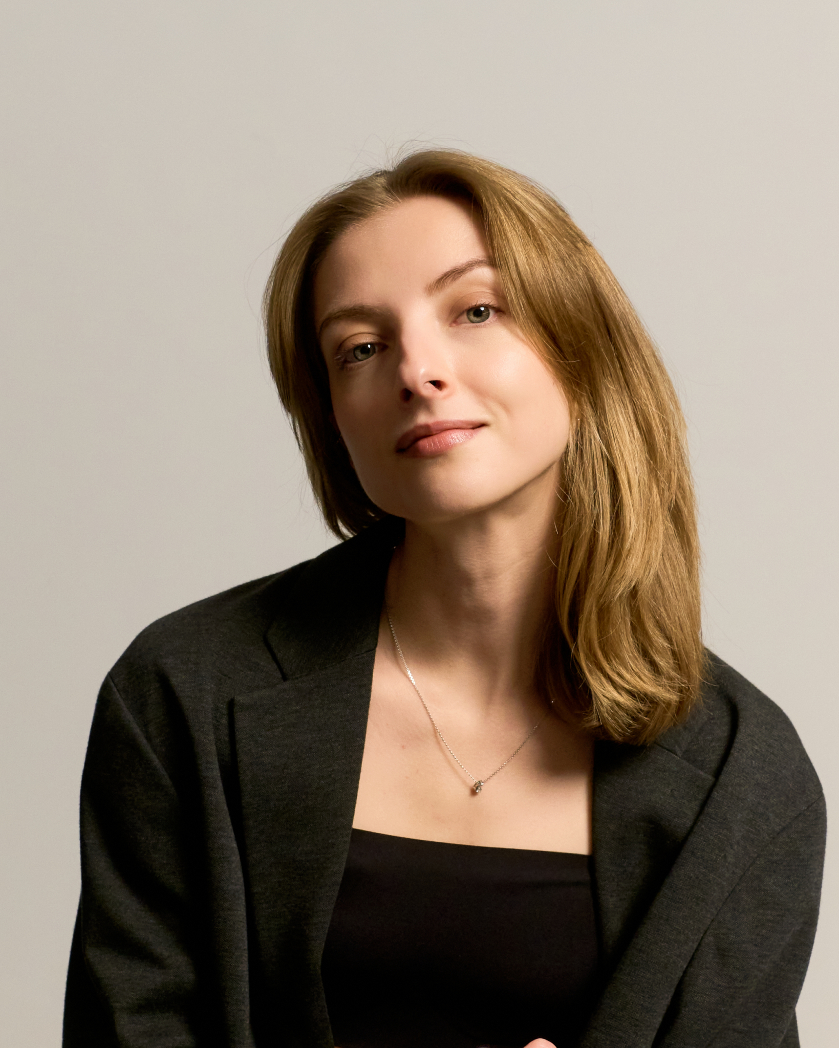 Mujer con blazer negro en sesión de self-portrait en estudio profesional