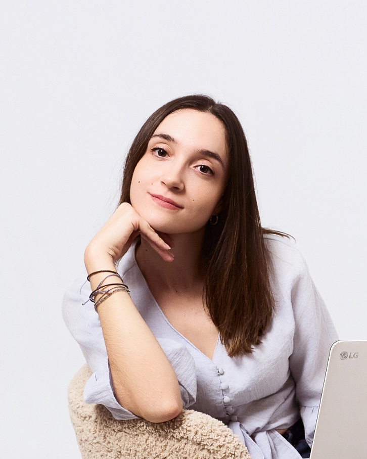 Woman in white shirt, relaxed professional pose, studio headshot