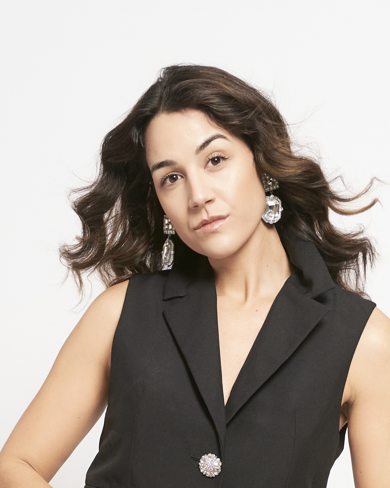 Mujer con chaleco negro y pendientes en foto profesional para LinkedIn