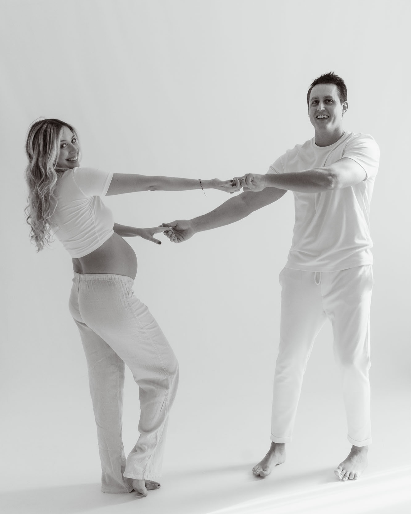 pareja bailando cogidos de las manos fotos embarazo divertidas estudio blanco negro