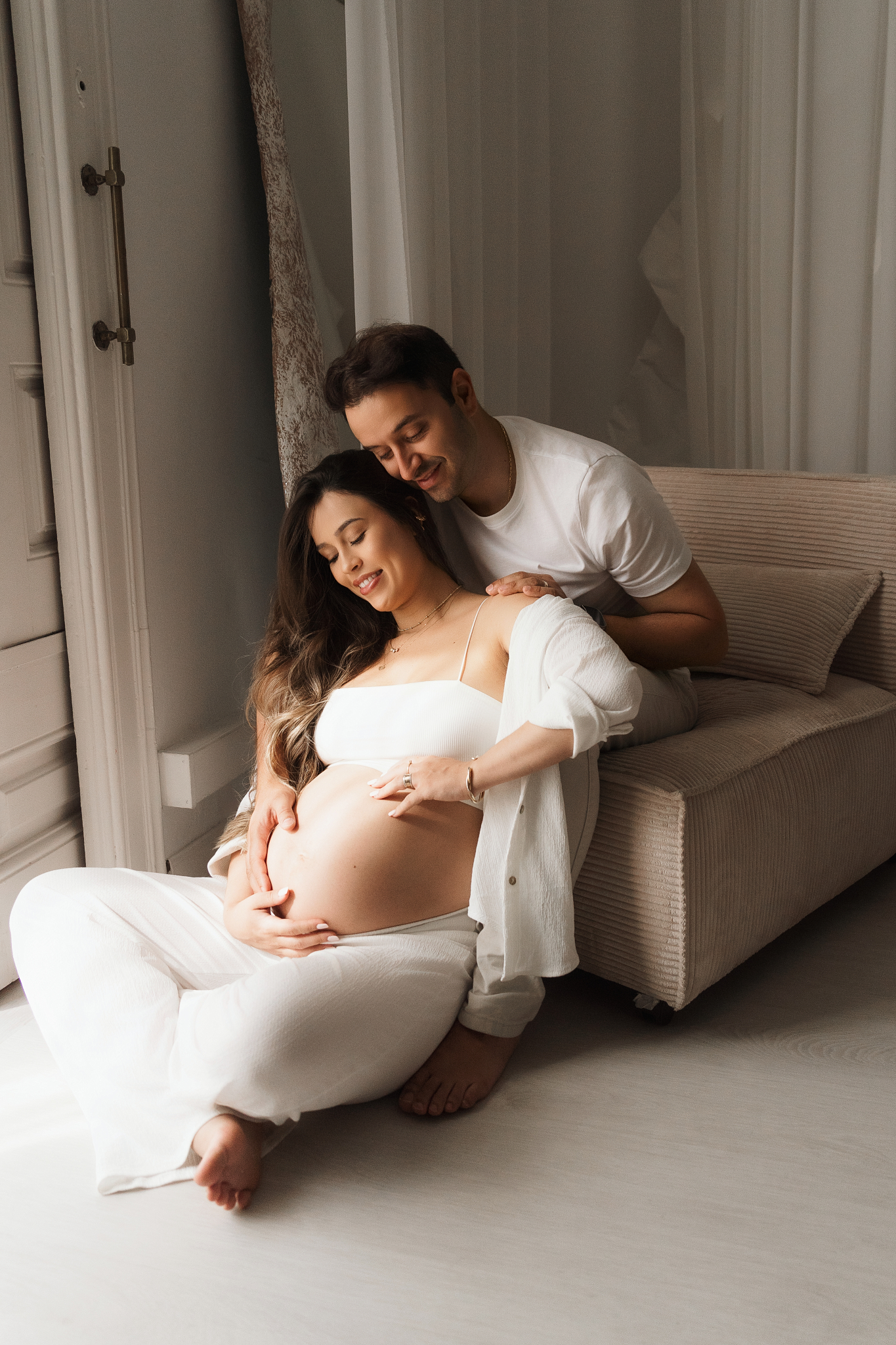 pareja fotos embarazo abrazo sofa luz natural barriga al aire