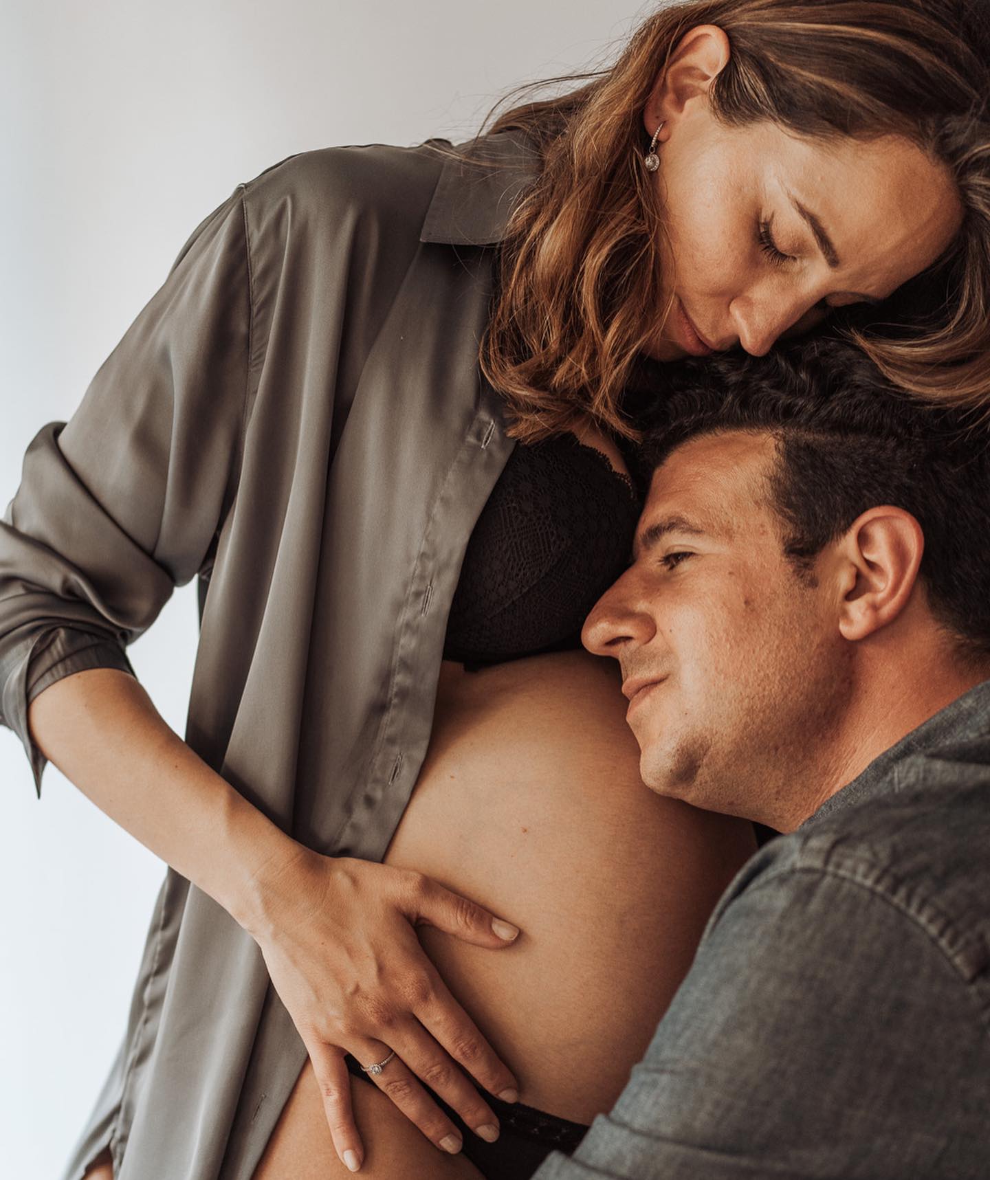 pareja sesion fotos embarazada ropa casual papa escuchando barriga mama blusa gris