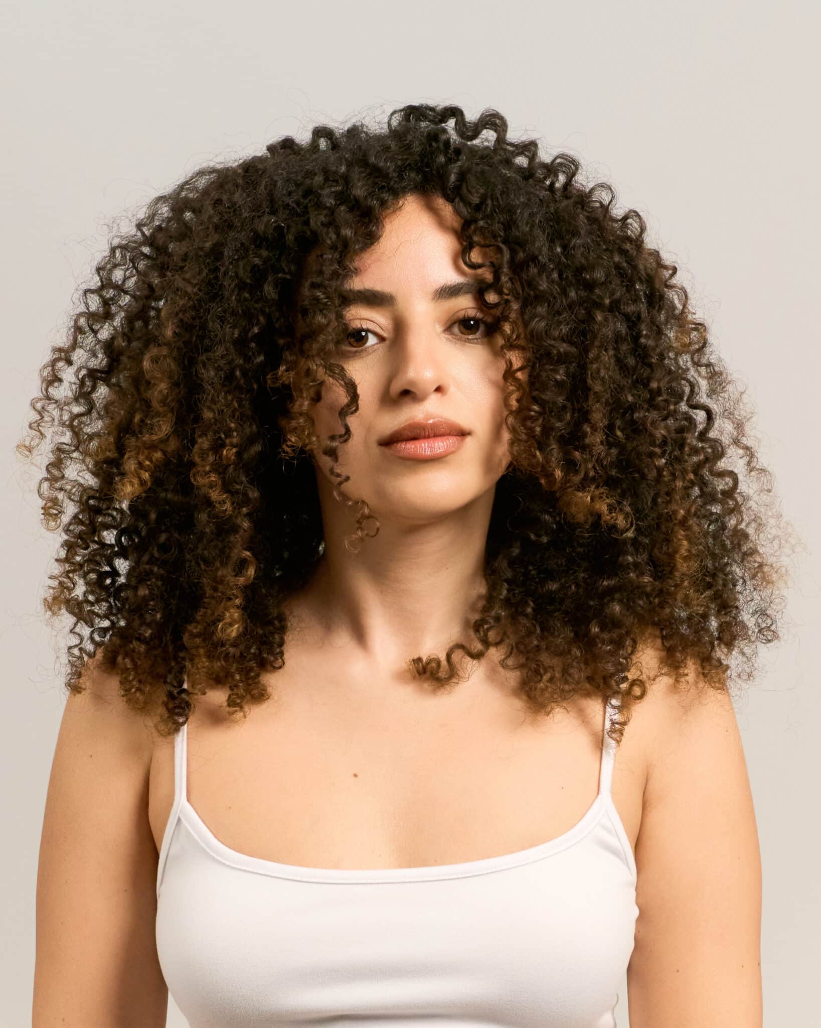 Woman with natural curly hair in a professional photo session for LinkedIn — a real alternative to an AI headshot