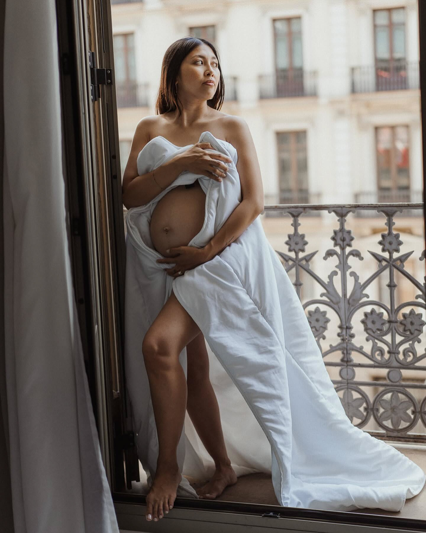 Pregnancy session with rebozo-style wrapped fabric on an Eixample balcony, Barcelona