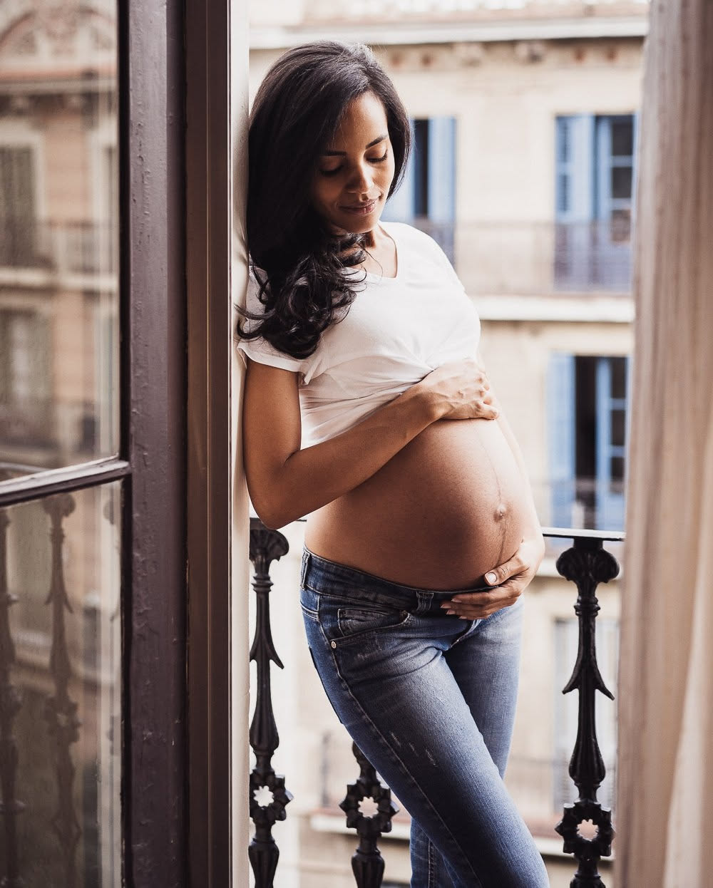 Pregnancy photo ideas on an Eixample balcony, Barcelona — front pose and calm gaze