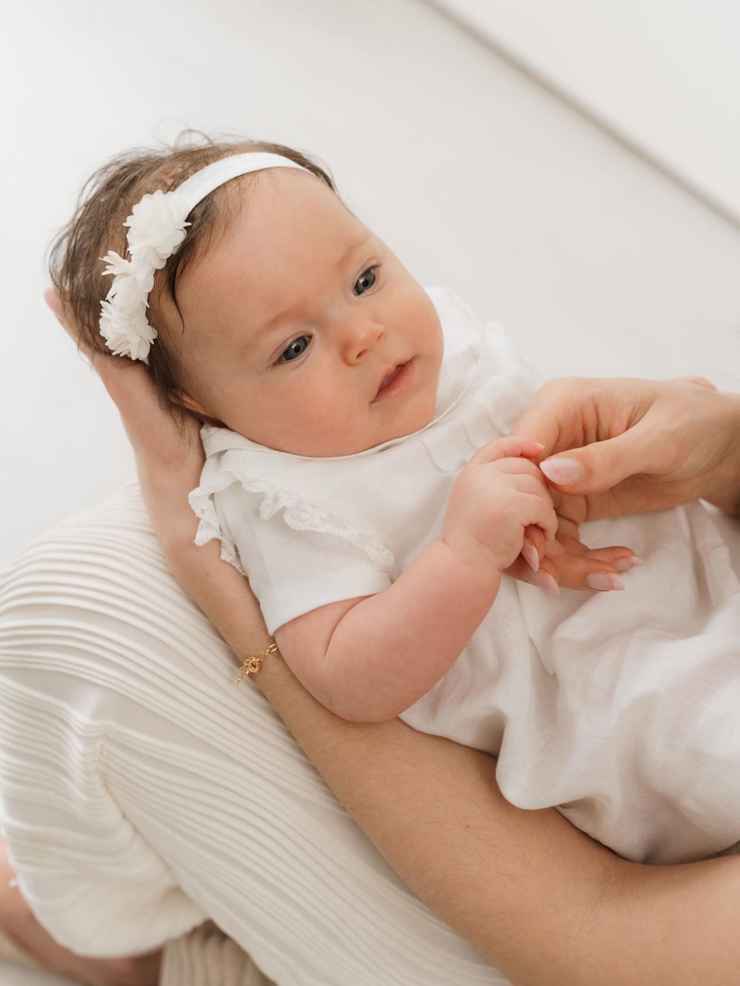 Bebé en brazos de su madre en sesión con fotógrafa profesional en Barcelona