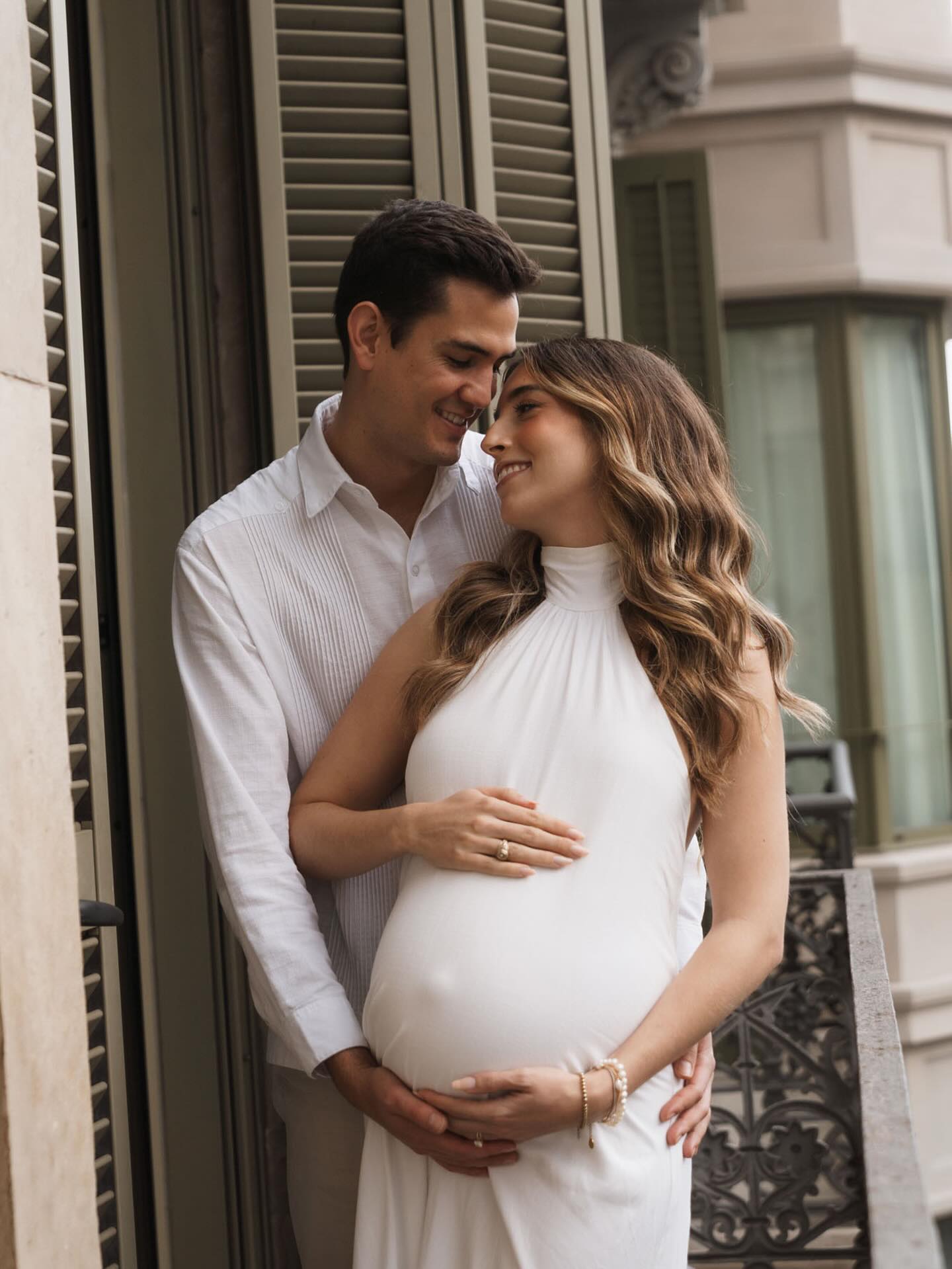 Pareja embarazada durante el babymoon en Barcelona — balcón modernista del Eixample