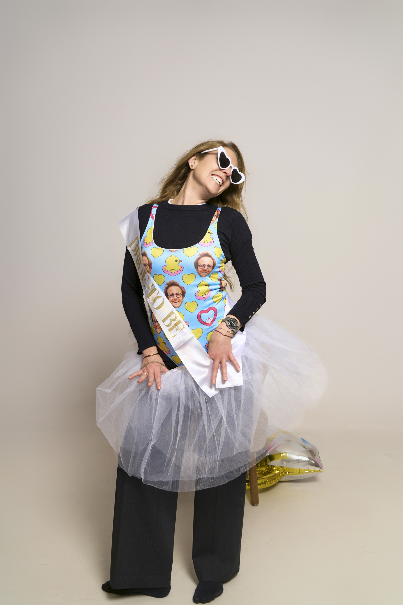 Novia con outfit Y2K en sesión de fotos despedida de soltera Barcelona — gafas mariposa de corazones, top con estampado, tutú blanco, banda Bride to Be