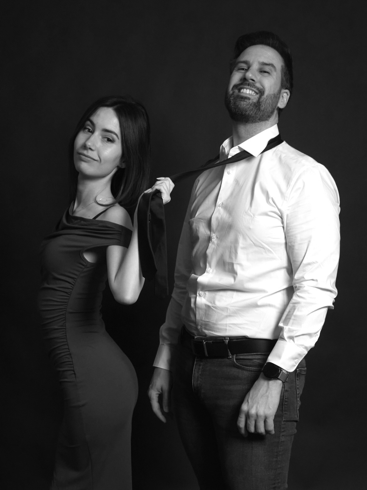 Couple shooting at YOULO Barcelona self-photo studio, black-and-white portrait with tie, dark background