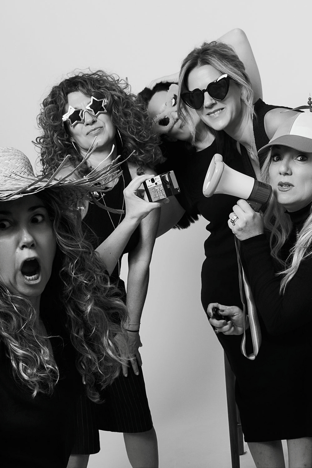 Group of friends posing with props and funny glasses during a photo session in Barcelona — an experience gift that replaces the typical material present