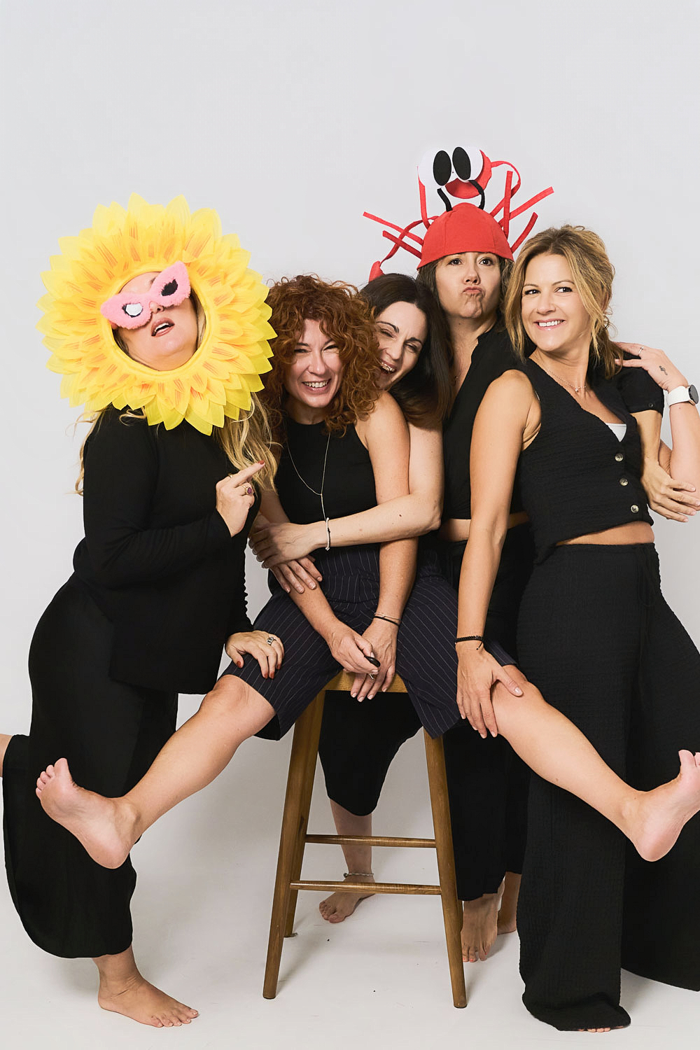 Group of five friends laughing with costumes and props during a self-photo session in the private YOULO studio in central Barcelona