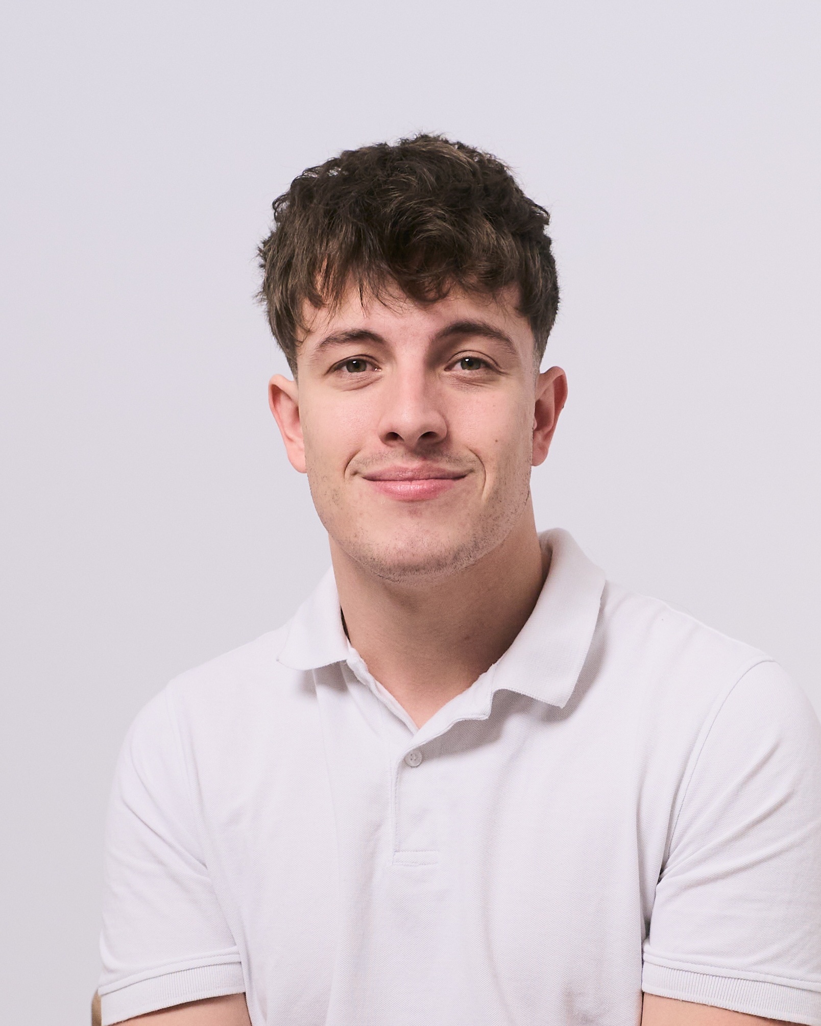 Professional portrait of a guy in a white t-shirt at YOULO Barcelona self-photo studio, grey background