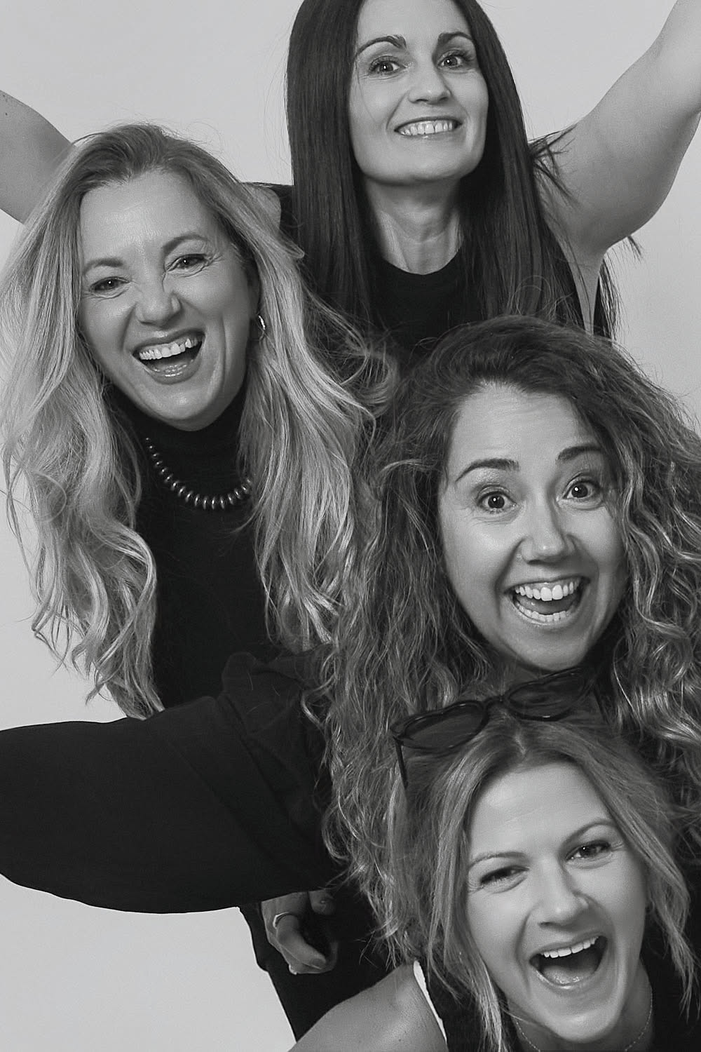 Group portrait of four friends laughing at a self photo studio in Barcelona, professional studio quality