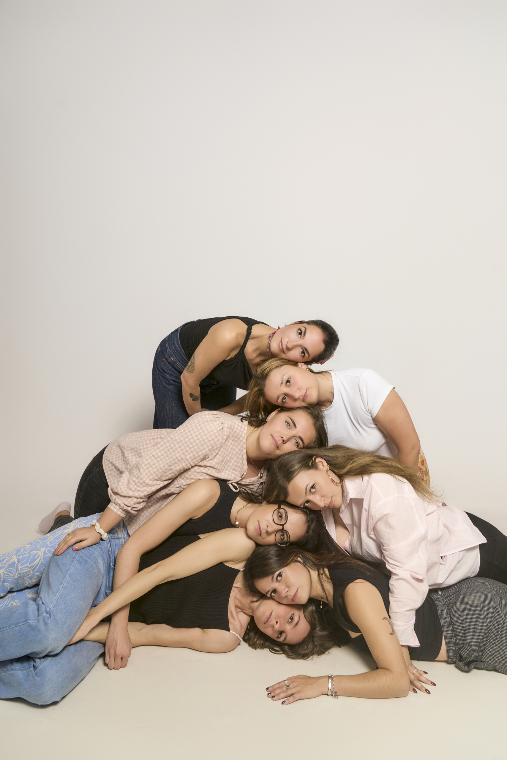 Grupo de amigas en sesión de fotos de despedida de soltera en estudio privado de Barcelona, composición creativa apoyadas unas sobre otras