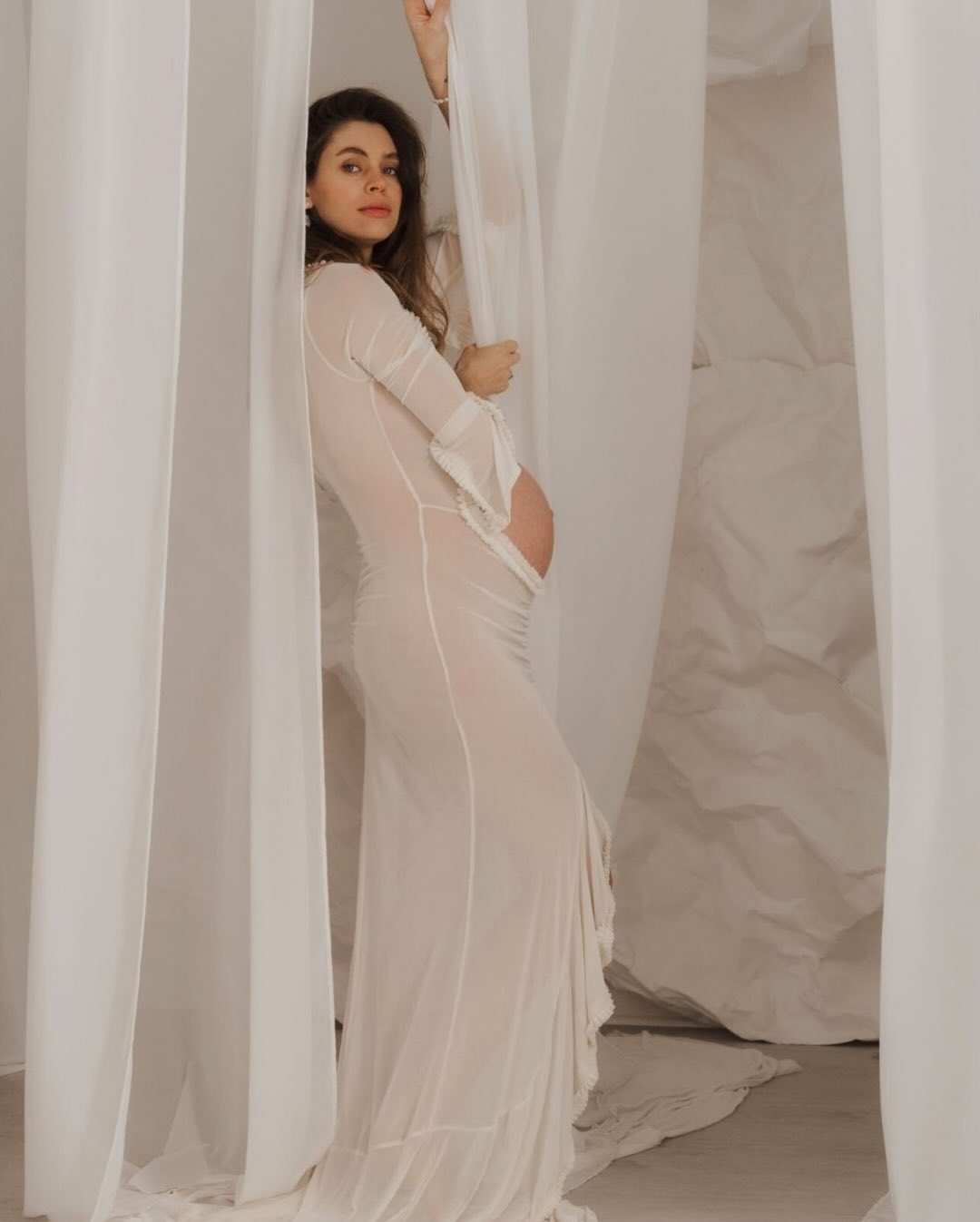 Embarazada con vestido premamá verde plisado en el estudio Wonderstory de Barcelona