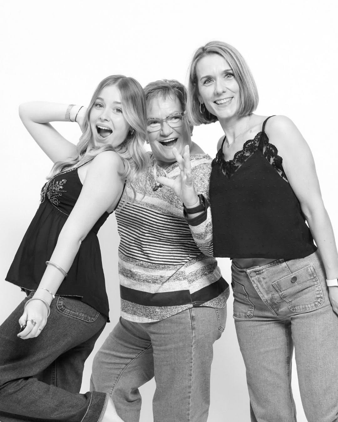 Three generations of women laughing together during a mixed-age birthday activity in Barcelona