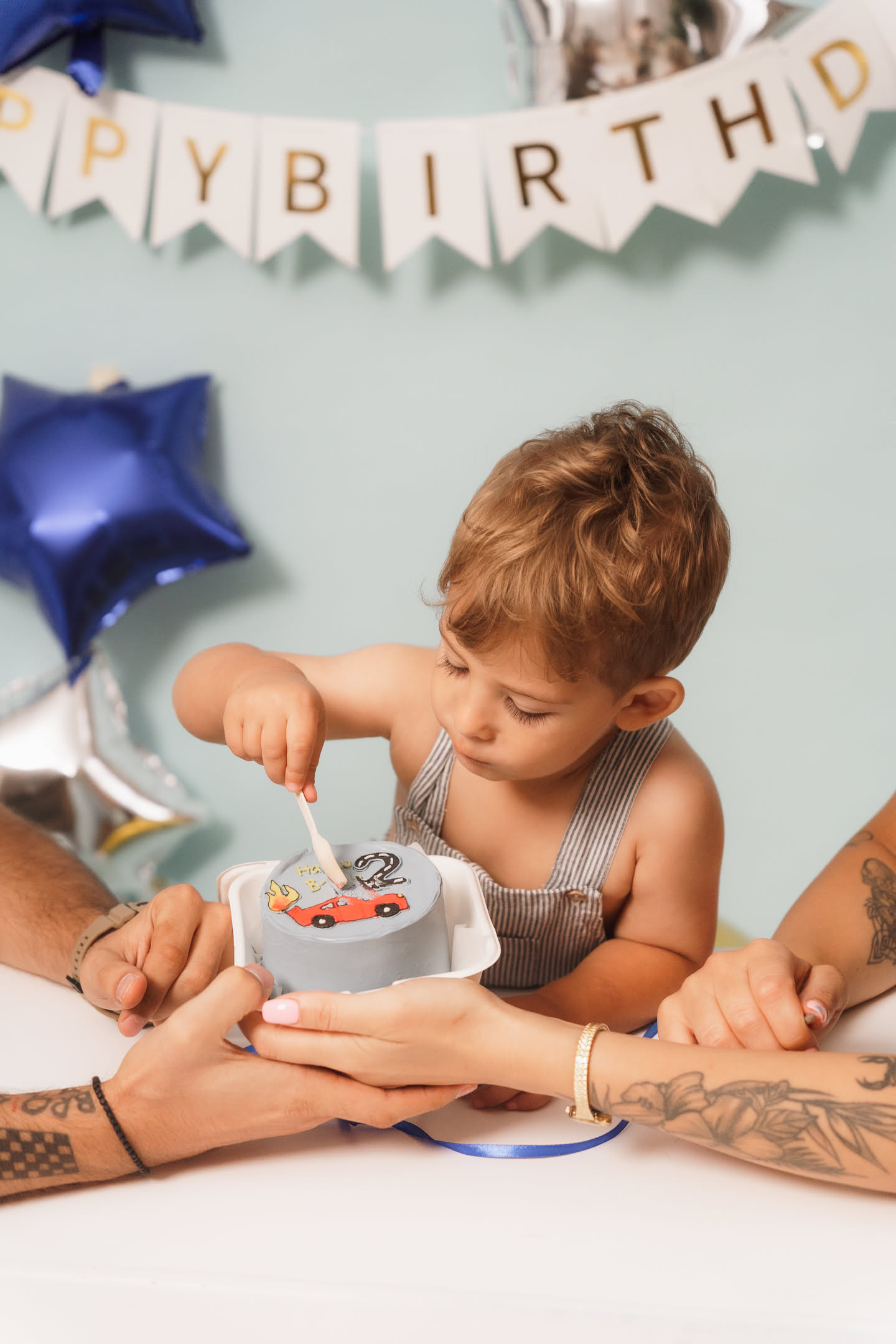 Kid with a birthday cake and Happy Birthday garland — the cake moment is one of the details people forget when booking