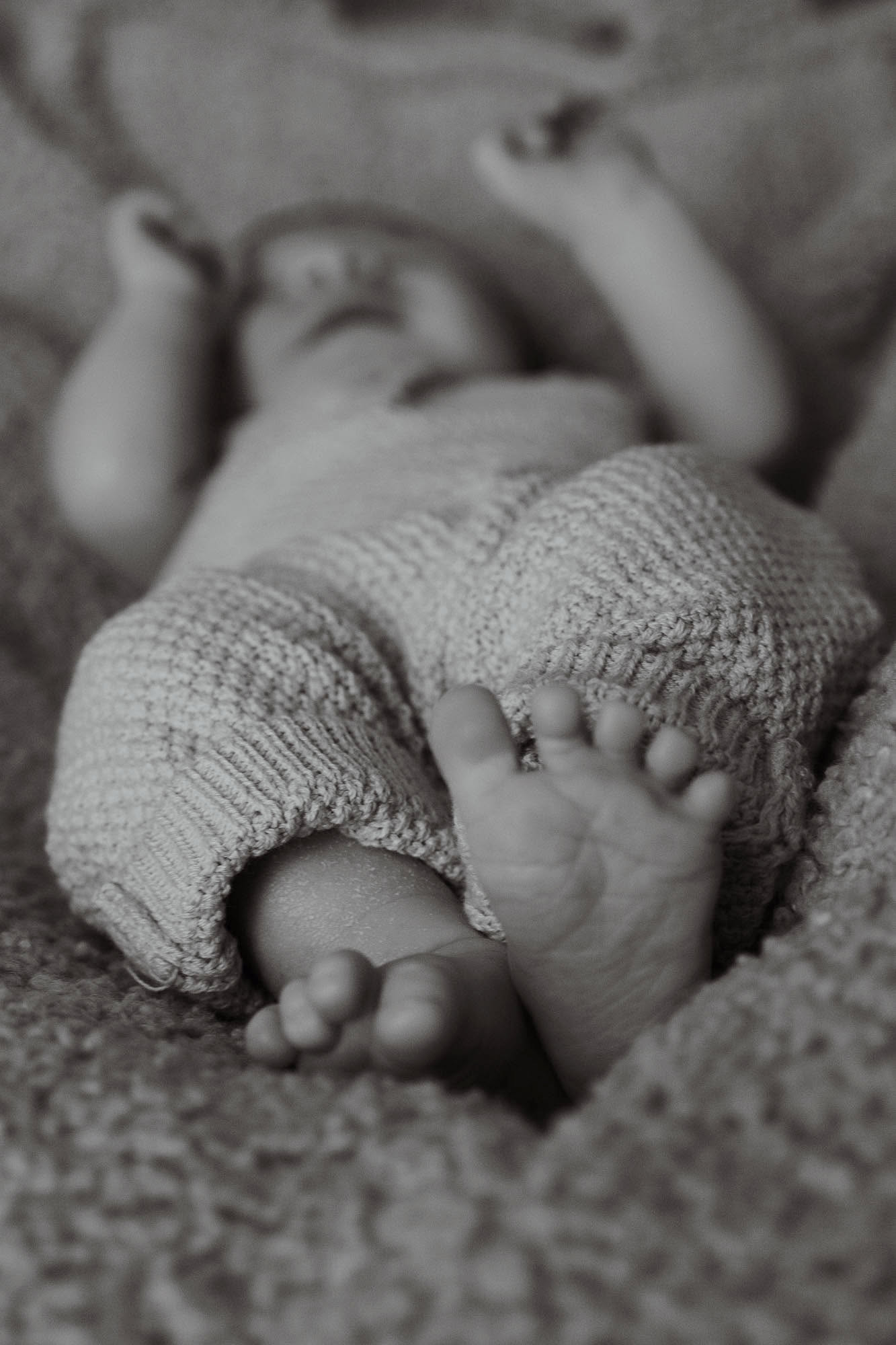 Newborn sleeping naturally in a soft cotton wrap during a Wonderstory studio session
