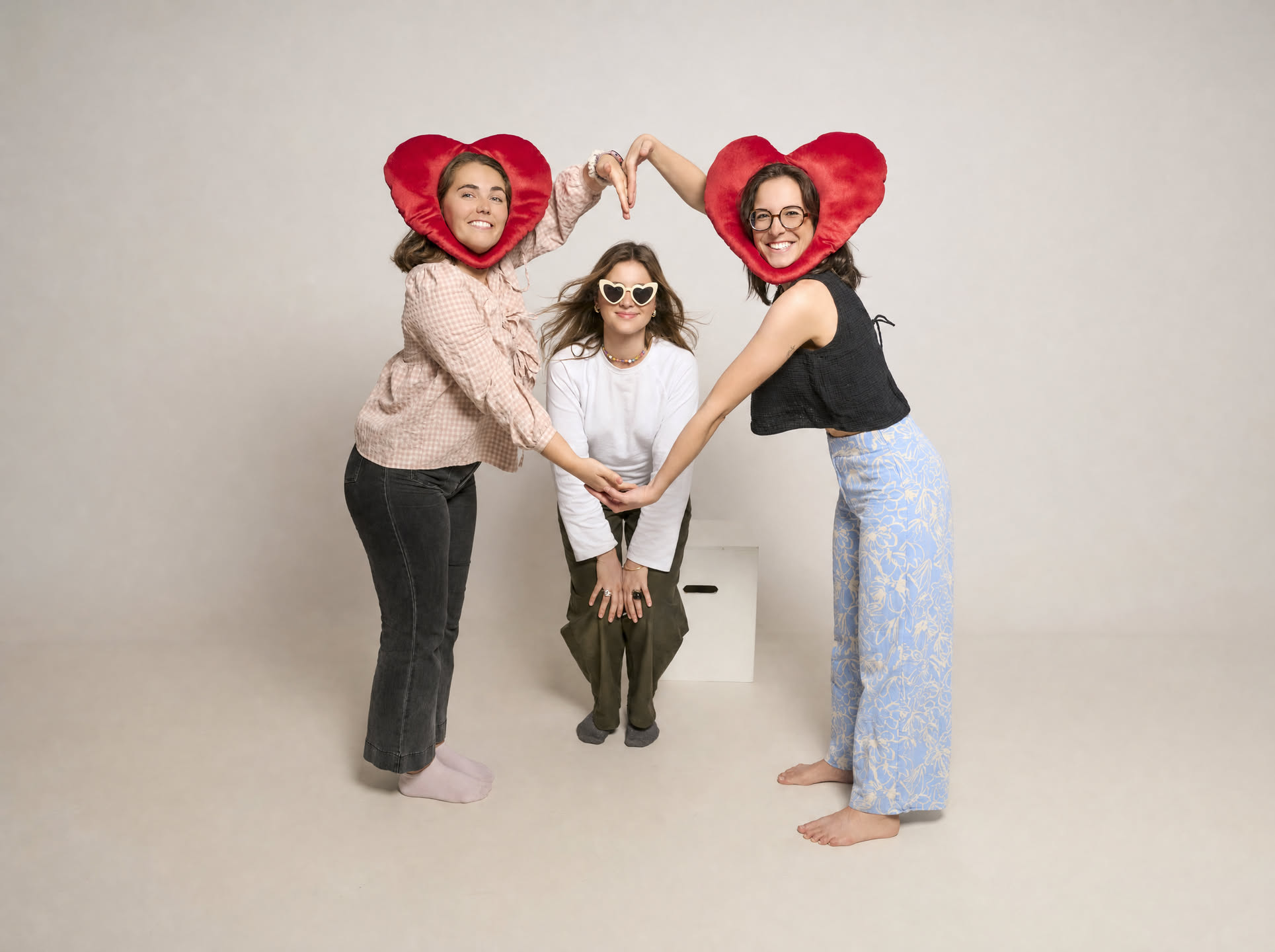Amigas formando un corazón con cojines, pose divertida en su despedida de soltera en Barcelona