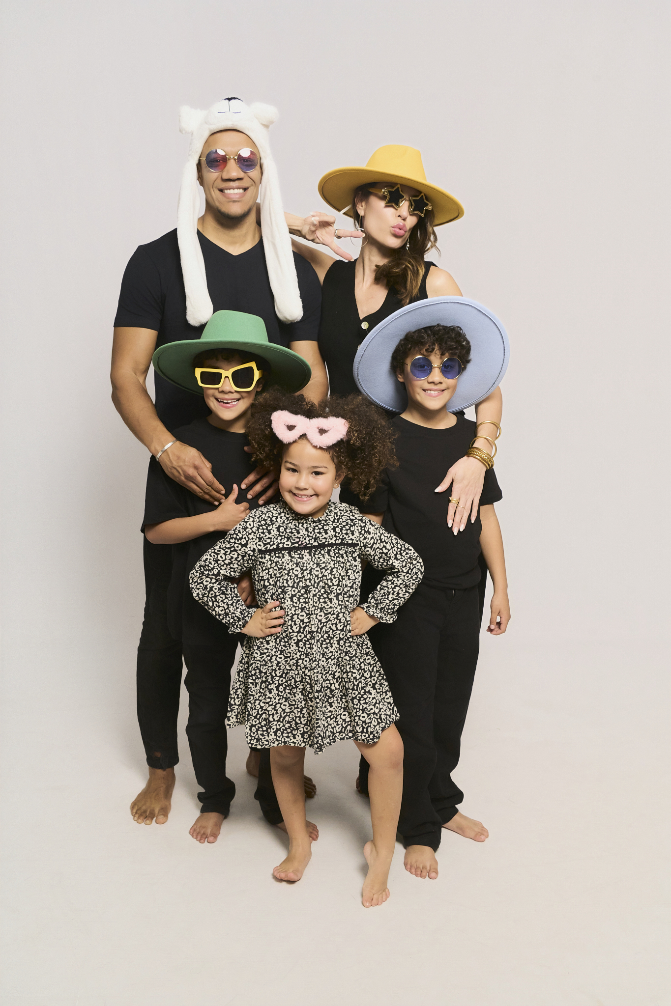 Familia con sombreros y gafas de atrezo en la sala privada de autofoto