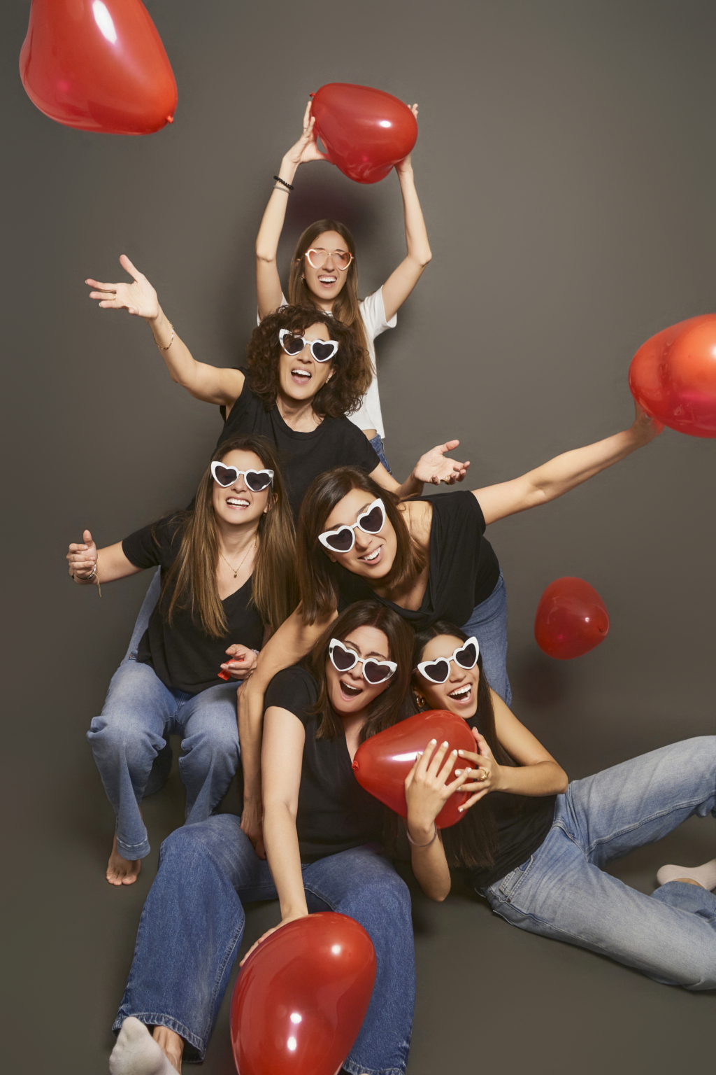 Grupo de amigas con globos de corazón y gafas divertidas