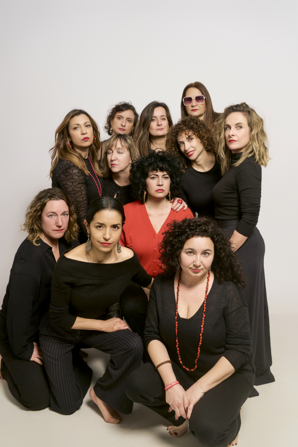 Grupo vestido de negro con un acento rojo en común
