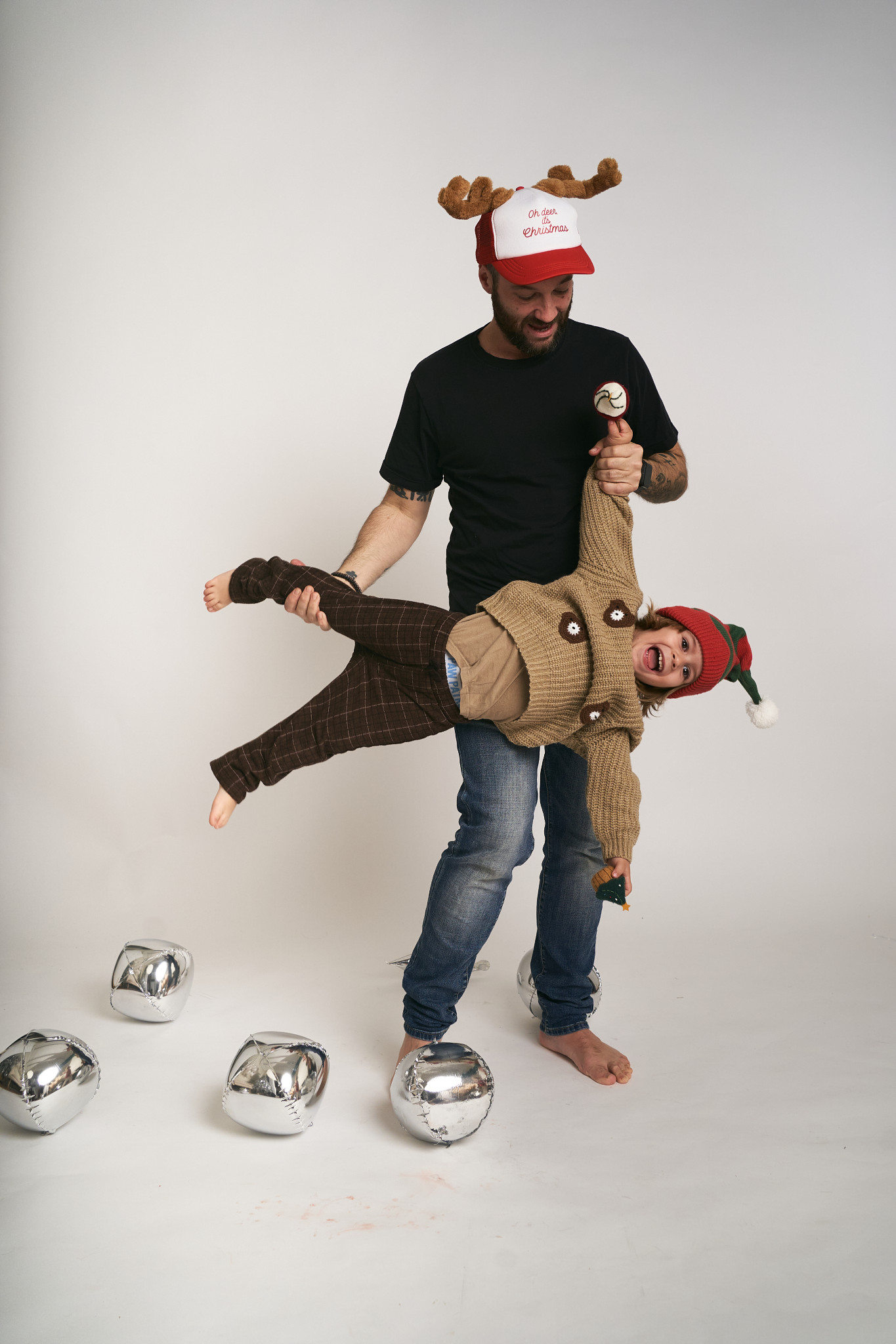 Padre e hijo con gorros de Navidad jugando delante de la cámara sin fotógrafo
