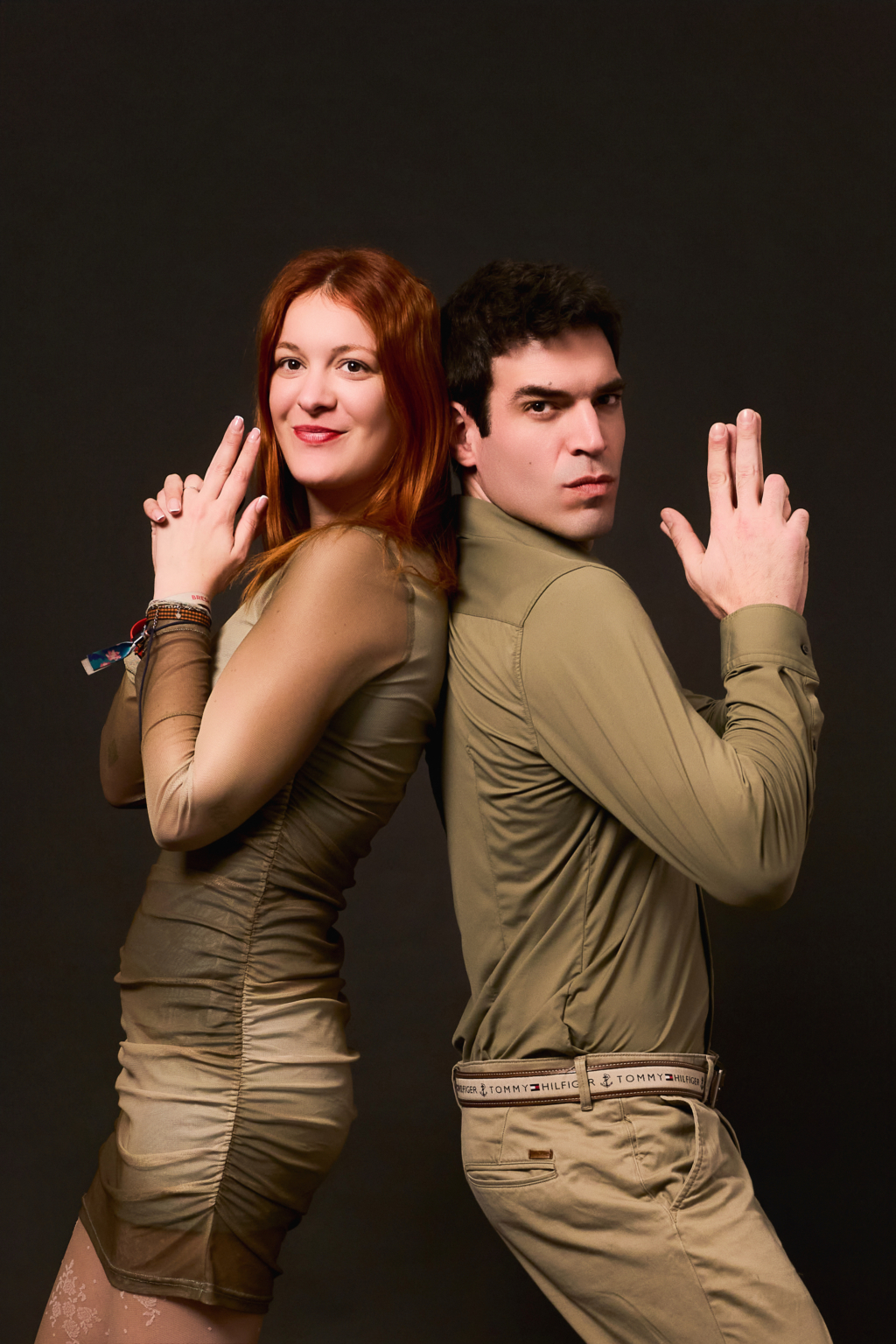 Pareja vestida en gama caqui sobre fondo oscuro