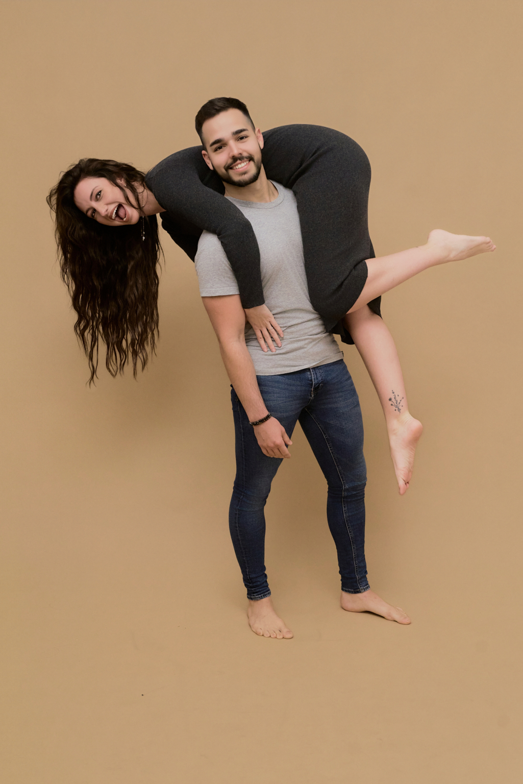 Pareja con look casual gris y denim, descalzos