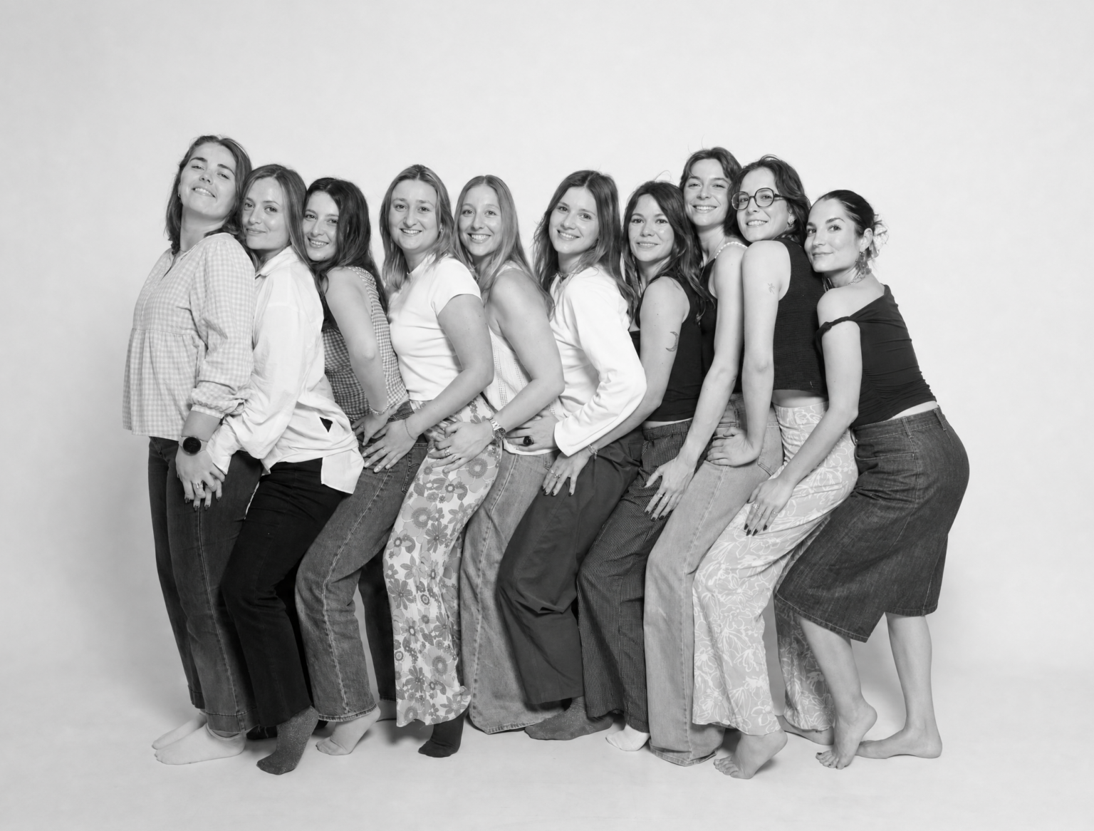Grupo grande de mujeres en una sesión de fotos revelada en blanco y negro