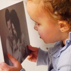 Toddler looking at black and white family photo.